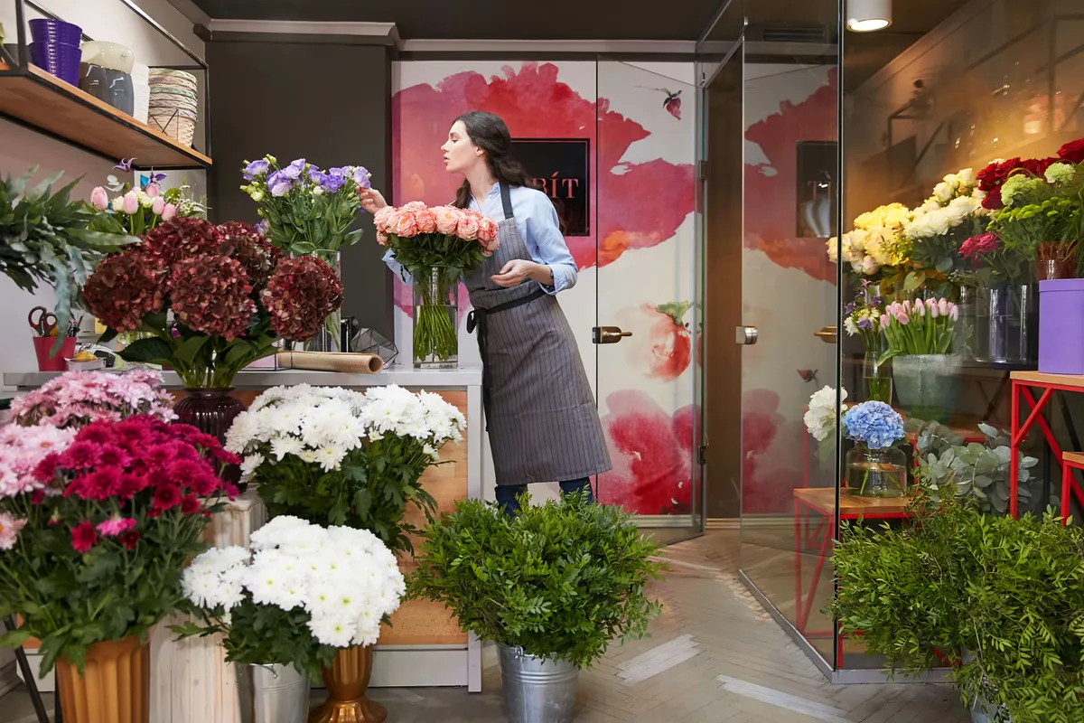 Florist arranging bunches of flowers in her shop